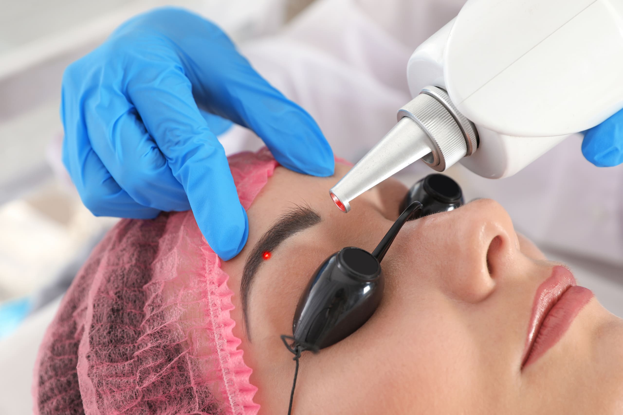 Lying Female Receiving Laser Treatment by Wearing Safety Googles | Noble Clinic in Draper, UT