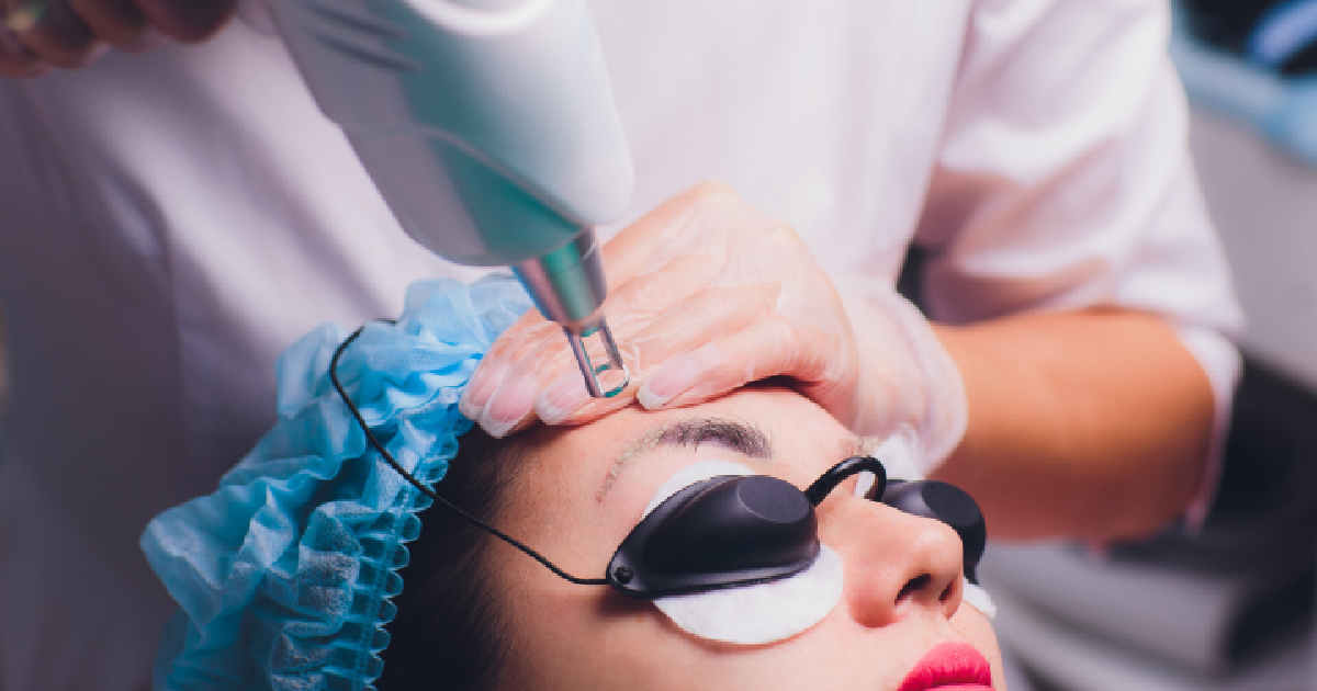 Woman in blue hairnet with eye shields receiving eyebrow tattoo removal treatment in Draper Utah